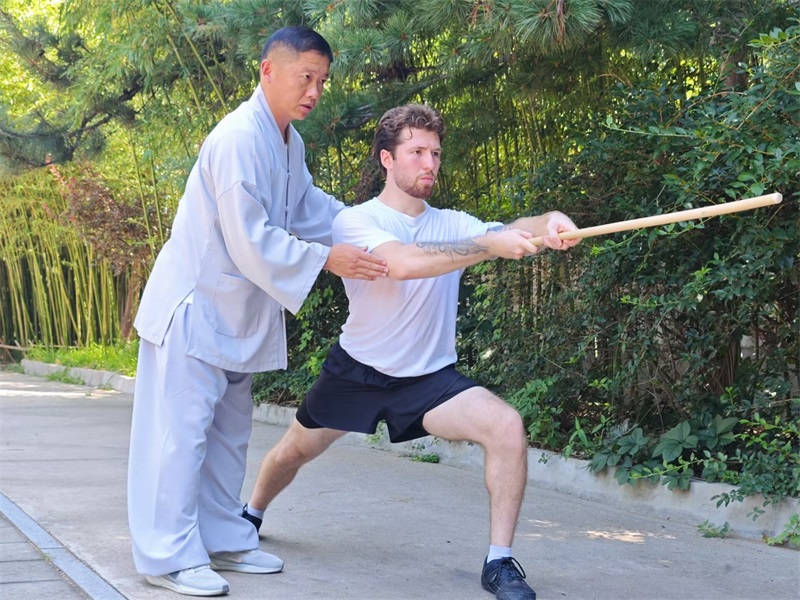 1787962992718762.jpg Master Zhang teaching students Shaolin staff